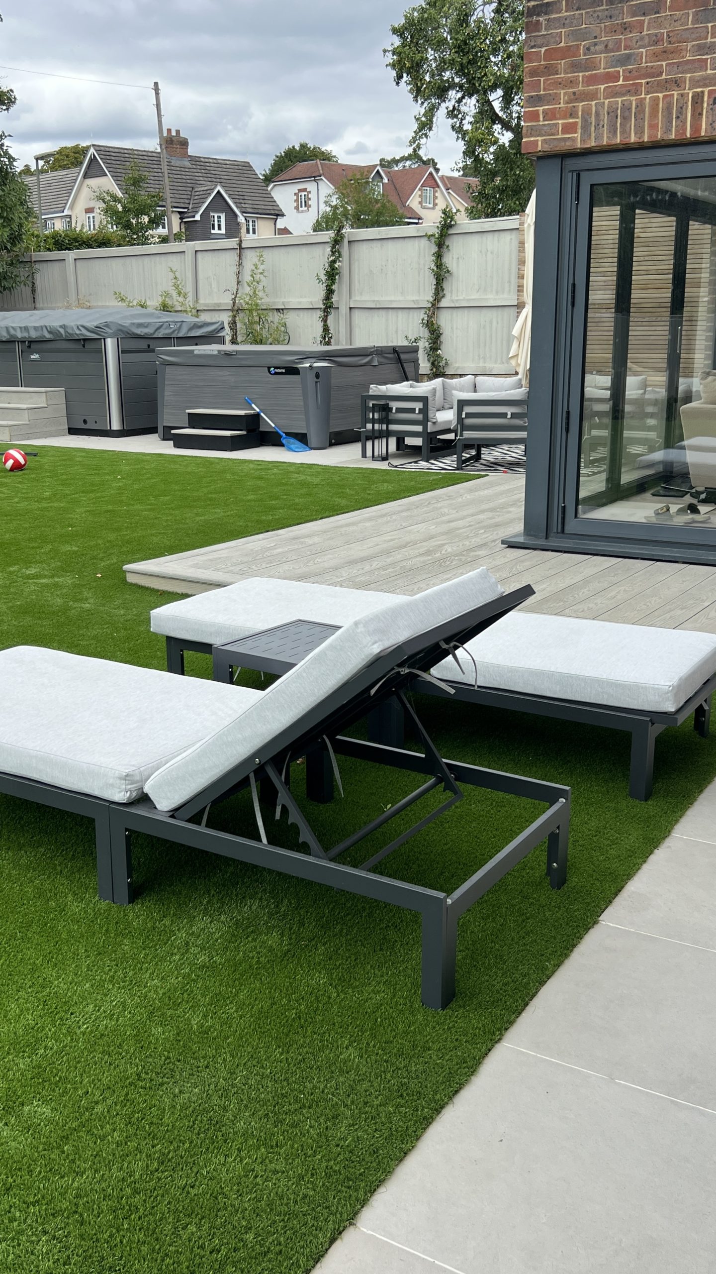 Millboard composite decking installation with outdoor lounge area and hot tub