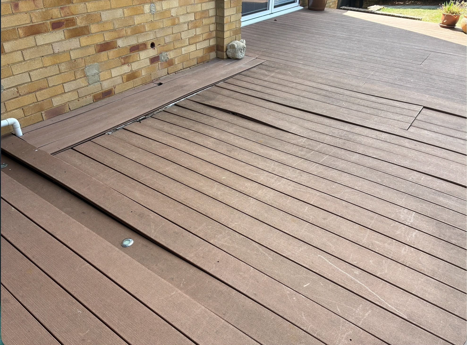 Before: buckled composite deck boards in Manchester
