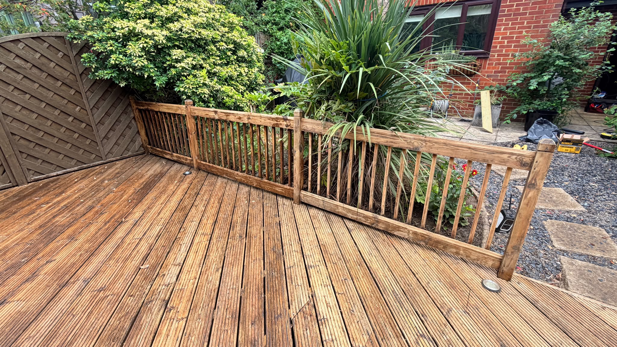 Trout Road Haslemere deck before — red brick wall with tools and materials staged